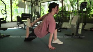 Woman is doing warming up and stretching in the gym before intense workout